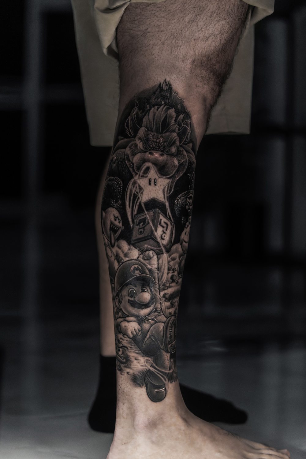 Black and grey video game leg sleeve tattoo