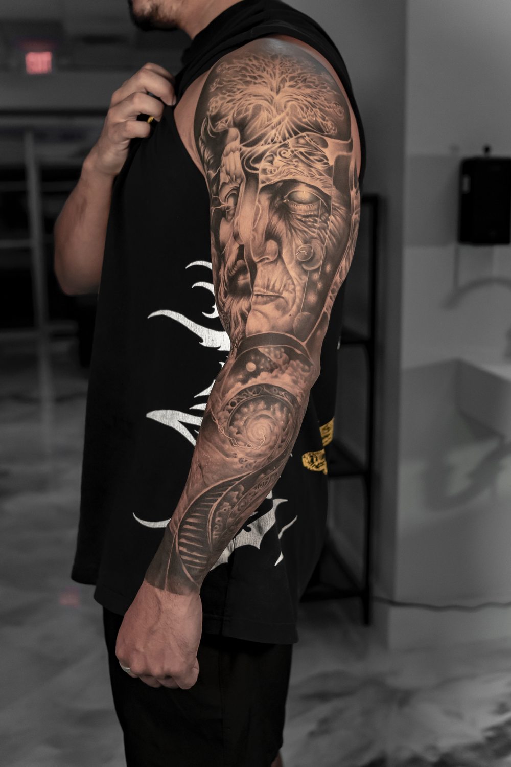 Black and grey surrealism full sleeve tattoo with a portrait and tree of life
