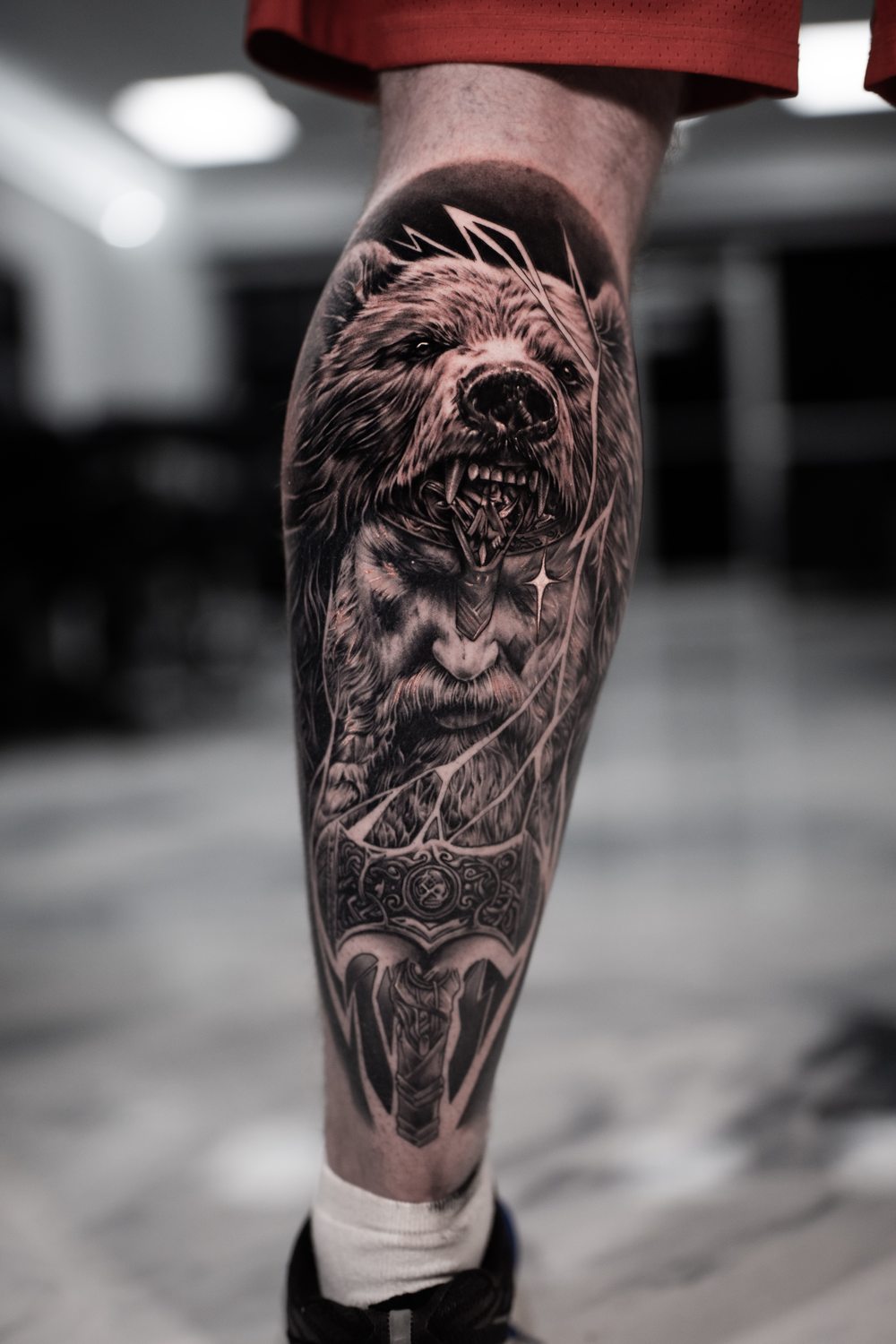 Black and grey bear and warrior tattoo on a calf