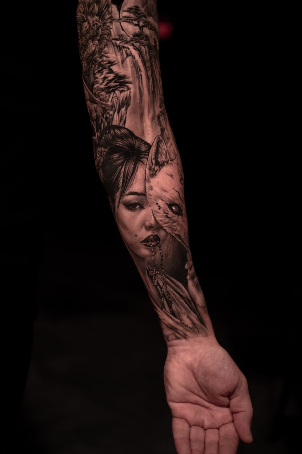 Black and grey geisha and fox tattoo on a forearm